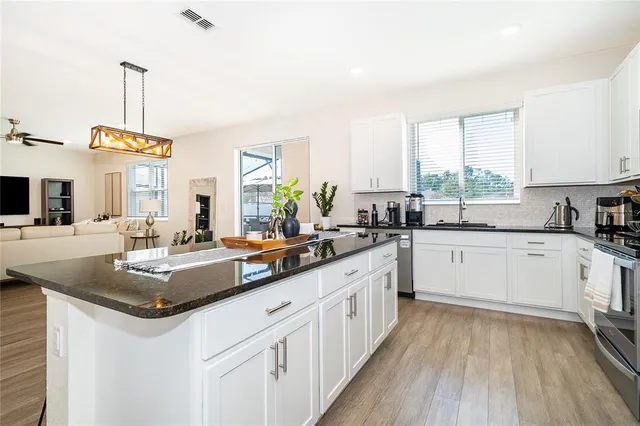 a kitchen with stainless steel appliances granite countertop a stove and a sink
