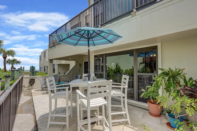 a view of a patio with a table and chairs under an umbrella