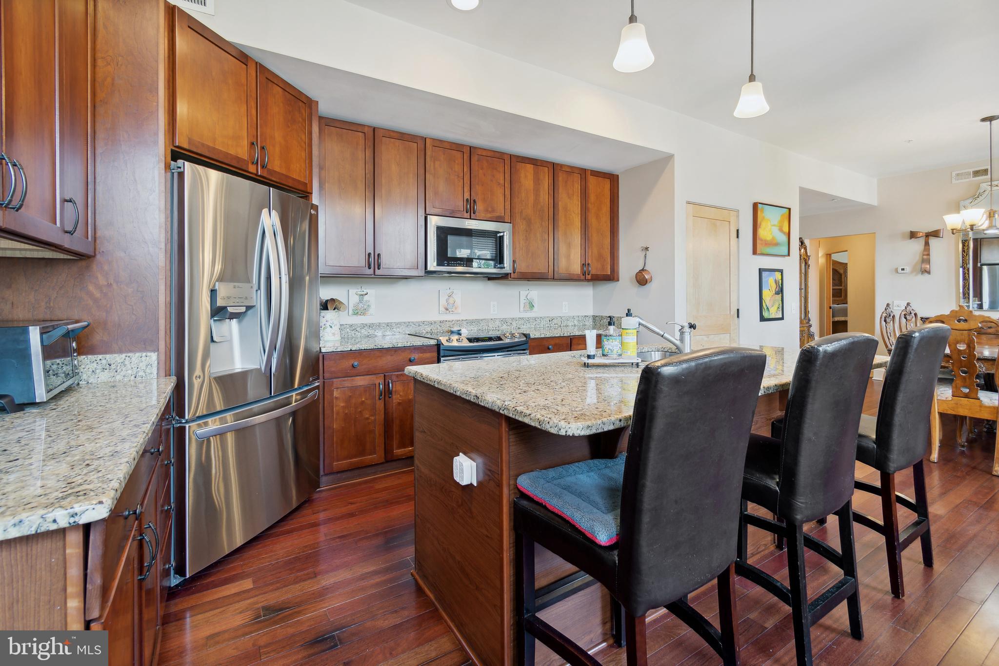 9610 Dewitt Drive, Unit B312 Silver Spring, MD 20910 - Photo 10 of 23 a kitchen with stainless steel appliances granite countertop a table chairs sink refrigerator and microwave