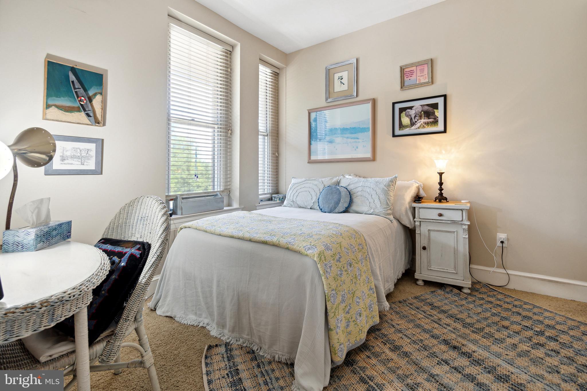 9610 Dewitt Drive, Unit B312 Silver Spring, MD 20910 - Photo 14 of 23 a bedroom with a bed and a table in it with window