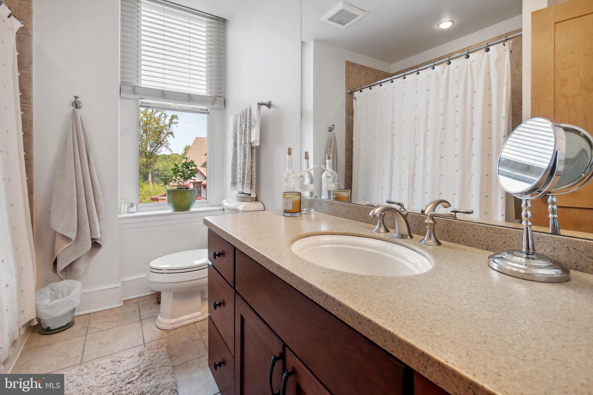 9610 Dewitt Drive, Unit B312 Silver Spring, MD 20910 - Photo 16 of 23 a bathroom with a granite countertop sink and a mirror