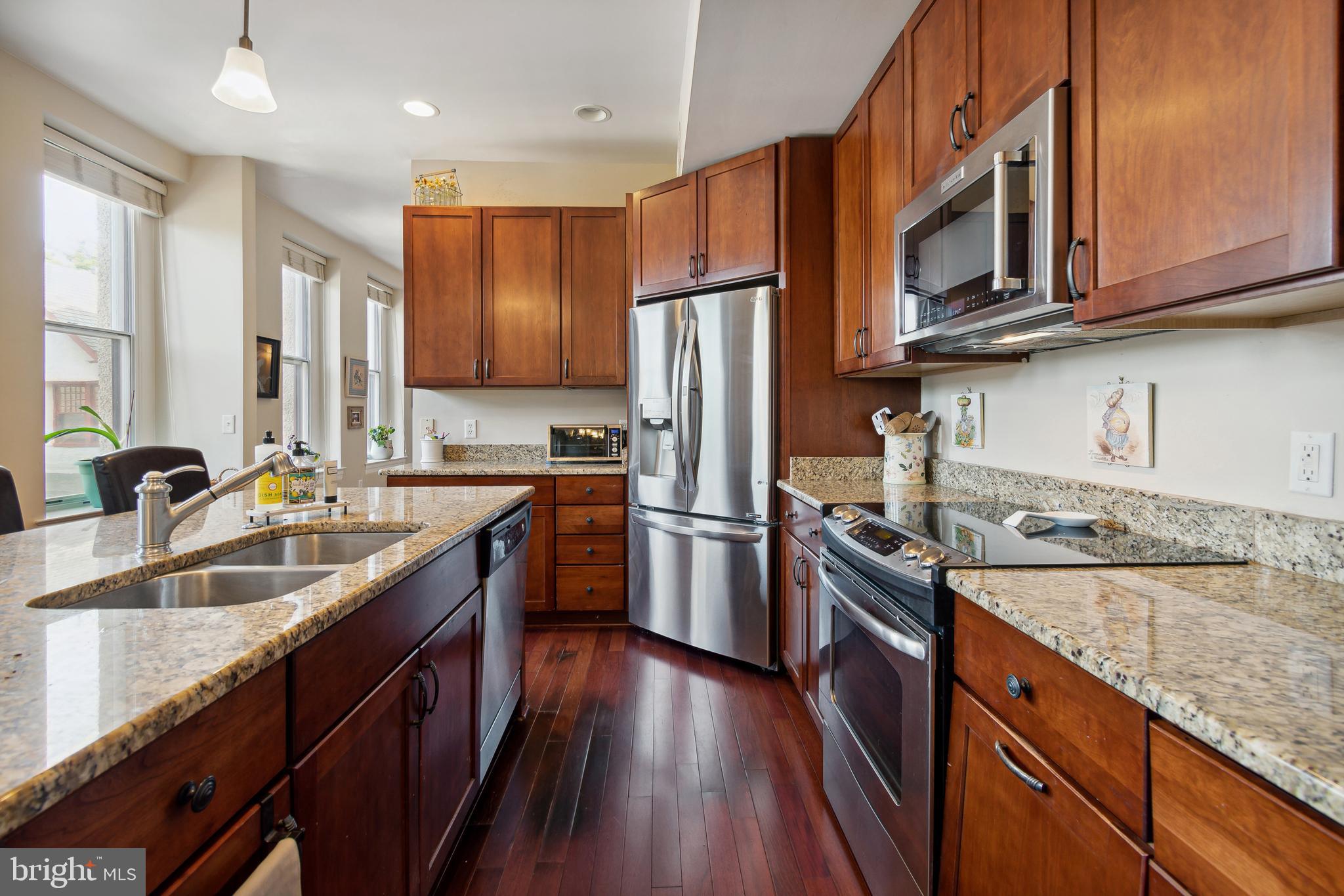 9610 Dewitt Drive, Unit B312 Silver Spring, MD 20910 - Photo 9 of 23 a kitchen with stainless steel appliances granite countertop a sink stove microwave and refrigerator