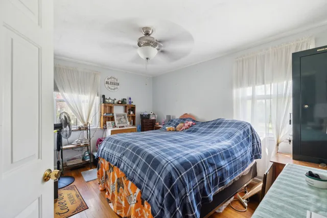 a bedroom with a bed and wooden floor