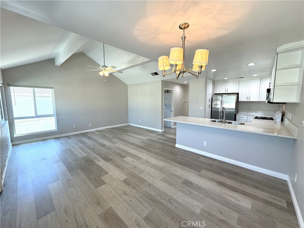 700 West Walnut Avenue, Unit 8 Orange, CA 92868 - Photo 4 of 11 an open kitchen with wooden floor and white cabinets