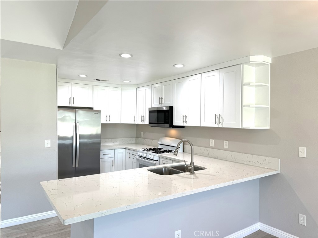 700 West Walnut Avenue, Unit 8 Orange, CA 92868 - Photo 5 of 11 a kitchen with stainless steel appliances granite countertop a sink a refrigerator and white cabinets