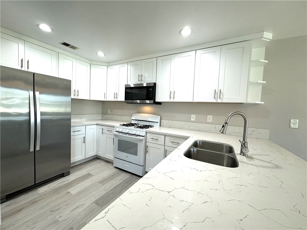 700 West Walnut Avenue, Unit 8 Orange, CA 92868 - Photo 6 of 11 a kitchen with a refrigerator sink and white cabinets
