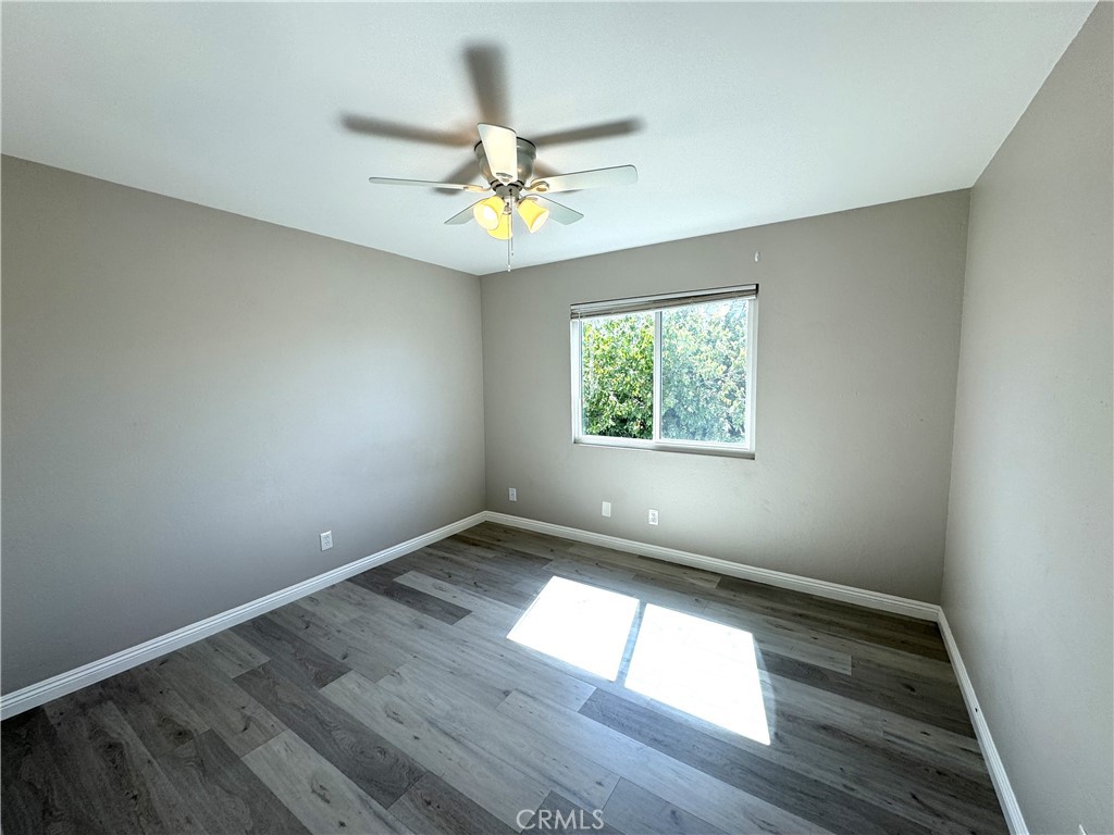 700 West Walnut Avenue, Unit 8 Orange, CA 92868 - Photo 9 of 11 an empty room with wooden floor fan and windows