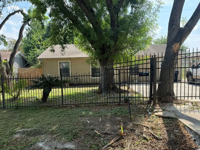 a view of house with a small yard and wooden fence