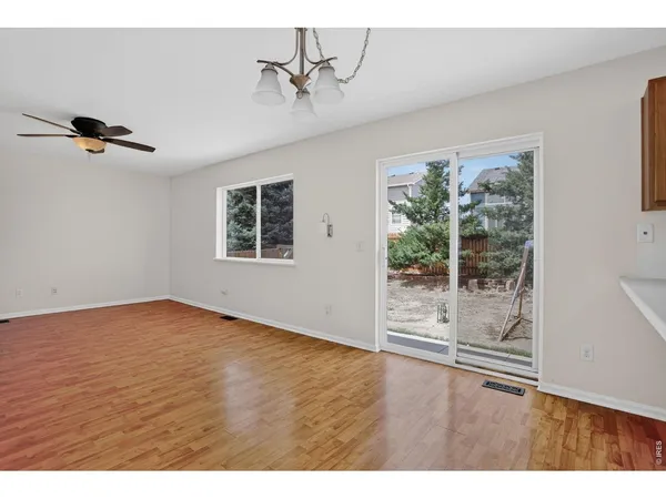 a view of empty room with wooden floor and window