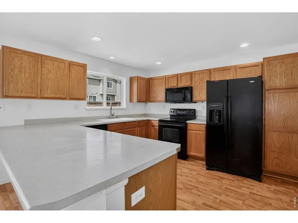 a large kitchen with a large counter top stainless steel appliances and cabinets