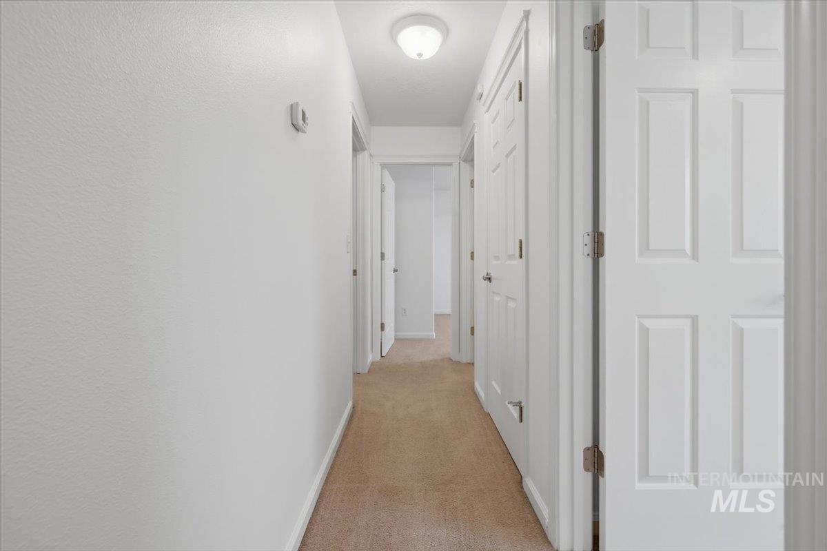 2075 North Springland Place Boise, ID 83713 - Photo 28 of 49 Central hallway featuring neutral-toned carpeting and white paneled doors