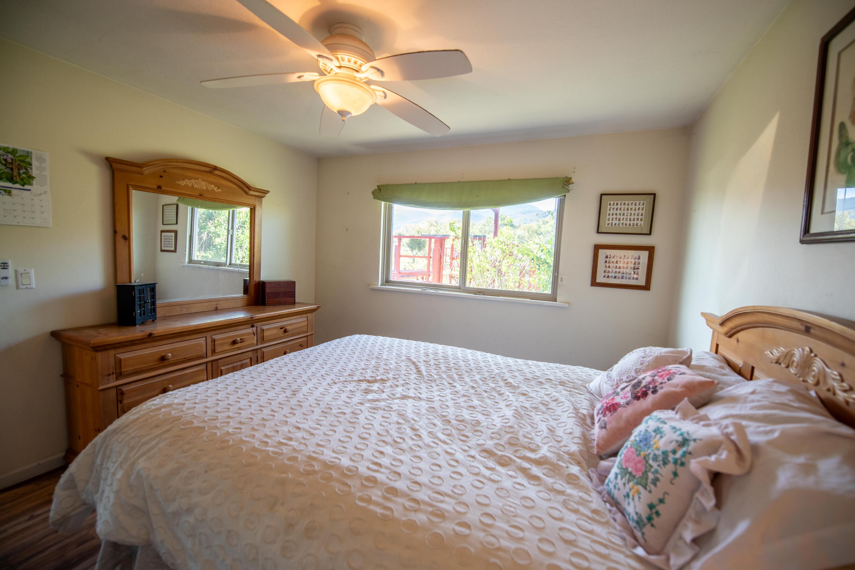 21970 Highline Road Tehachapi, CA 93561 - Photo 52 of 68 a bedroom with a bed and a chandelier