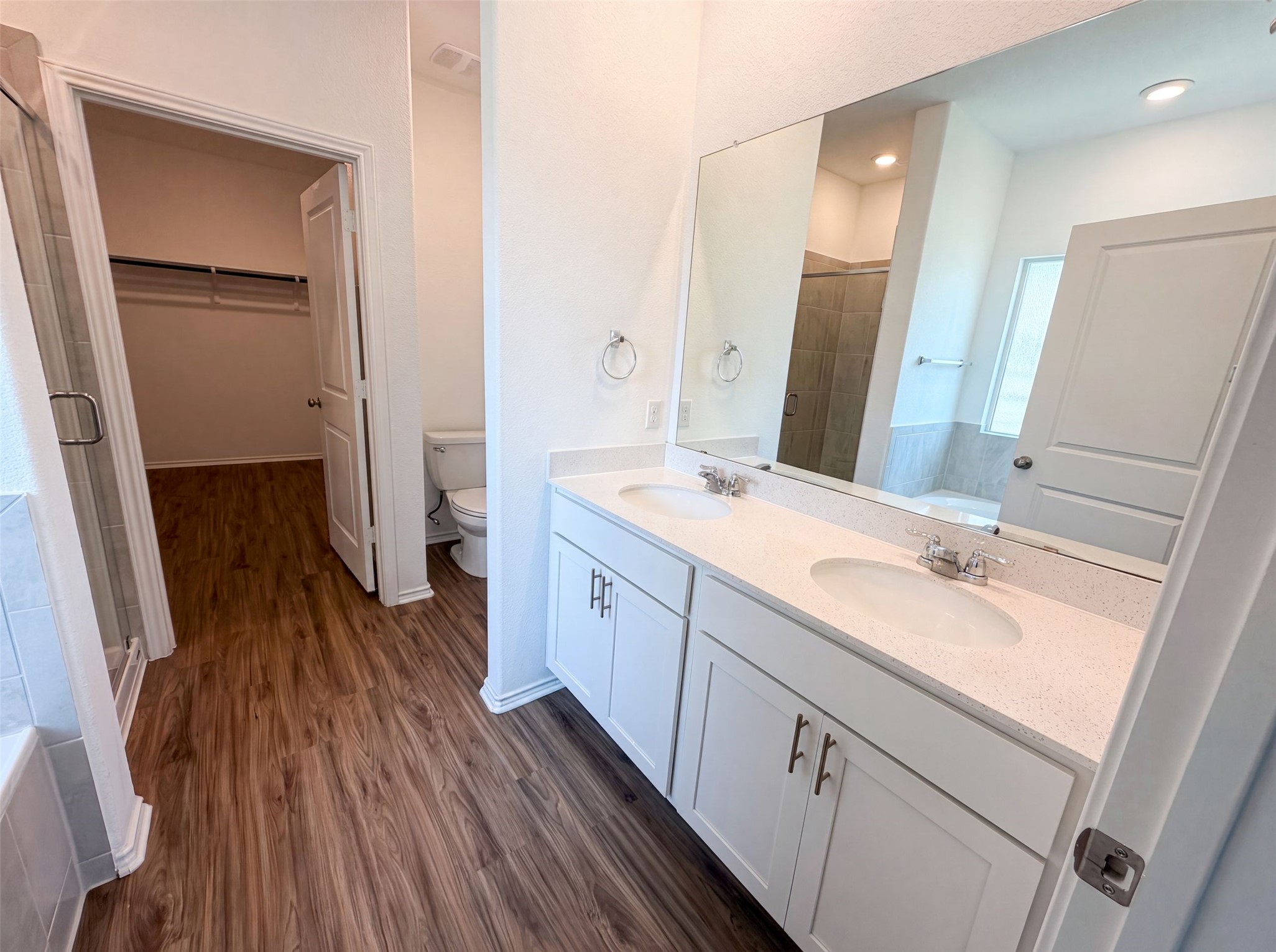 424 Wolf Springs Road Georgetown, TX 78628 - Photo 12 of 15 Double vanities and rich wood-tone flooring create a functional and pleasant bathroom space.