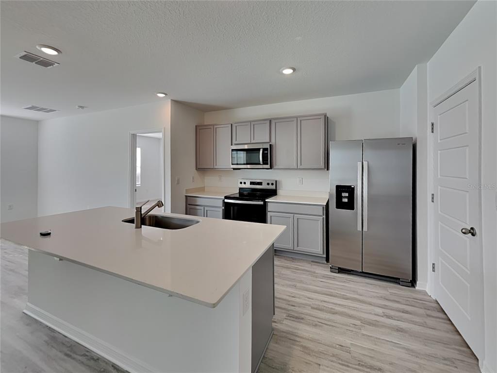 3515 Nettle Loop Tavares, FL 32778 - Photo 2 of 19 a kitchen with stainless steel appliances a refrigerator sink and microwave
