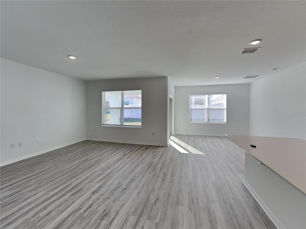 3515 Nettle Loop Tavares, FL 32778 - Photo 7 of 19 an empty room with wooden floor and windows
