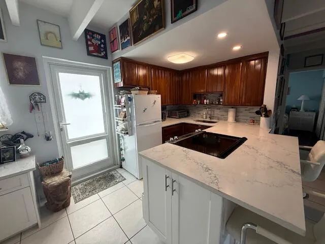 a kitchen that has a sink a refrigerator and cabinets