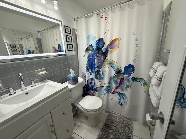4001 South Ocean Boulevard, Unit 218 South Palm Beach, FL 33480 - Photo 9 of 13 a bathroom with a toilet sink and mirror