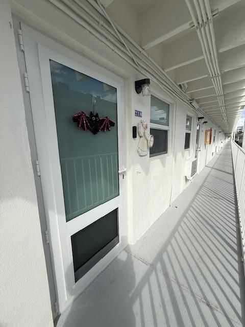 4001 South Ocean Boulevard, Unit 218 South Palm Beach, FL 33480 - Photo 10 of 13 a hallway with sliding door and front door