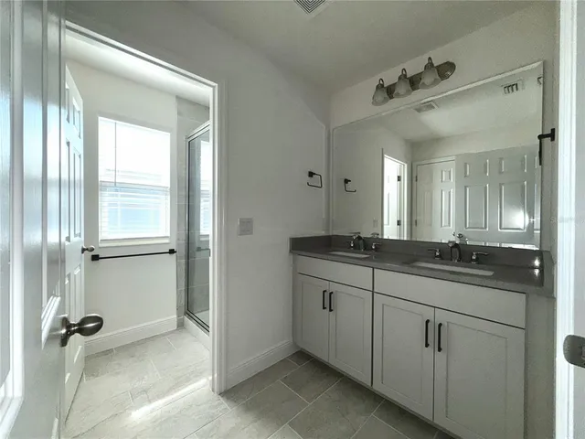 a bathroom with a granite countertop sink a mirror and a bathtub
