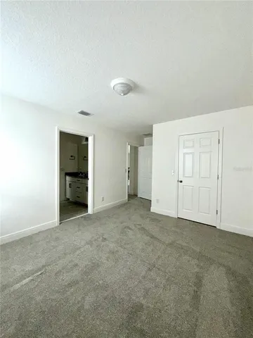 an empty room with an entryway and closet