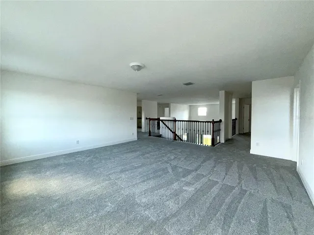 an empty room with an empty space and kitchen view