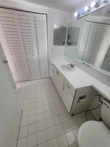 a bathroom with a sink a toilet and mirror