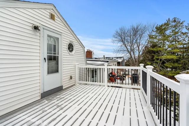 a view of a balcony with chairs and wooden floor