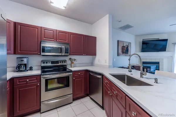a kitchen with stainless steel appliances granite countertop a sink dishwasher stove and oven with cabinets