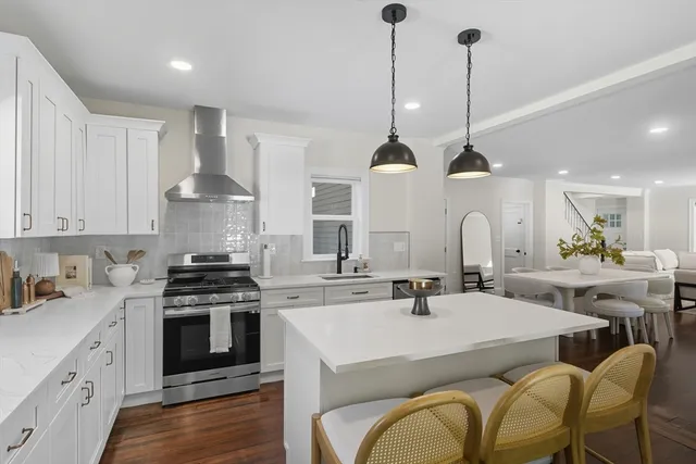 a kitchen with stainless steel appliances a stove a sink a oven a stove and a wooden floors