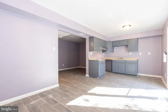 a view of a kitchen with wooden floor and white walls