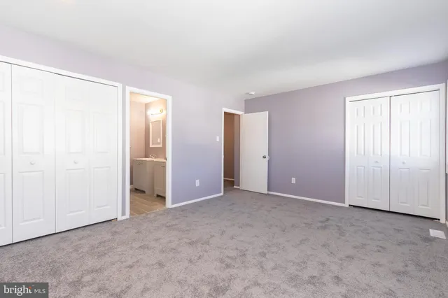 an empty room with windows and closet
