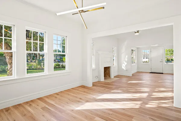 a view of an empty room with window and wooden floor