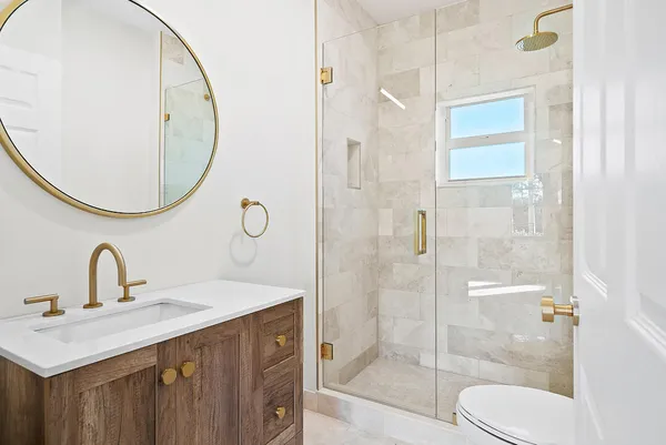 a bathroom with a sink vanity mirror and toilet