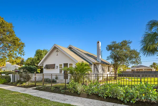 a view of house with garden and tall trees