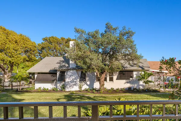 a front view of a house with a garden and swimming pool