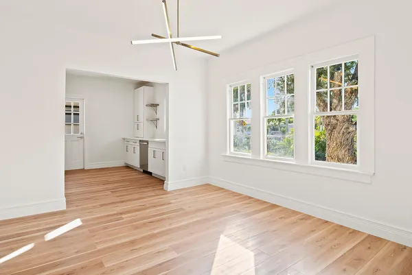 a view of empty room with wooden floor and window