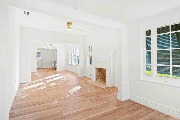 a view of a bedroom with wooden floor and windows