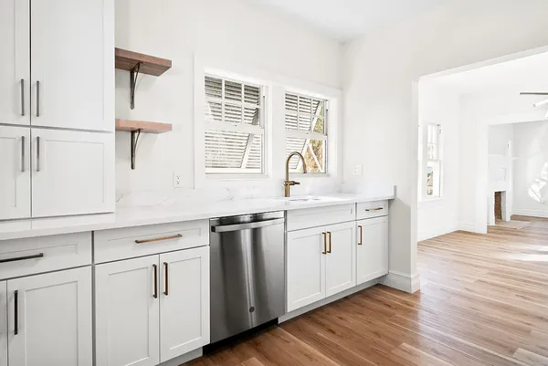 a kitchen with granite countertop white cabinets and white appliances