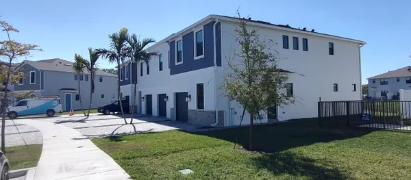 a patio with table and chairs and potted plants