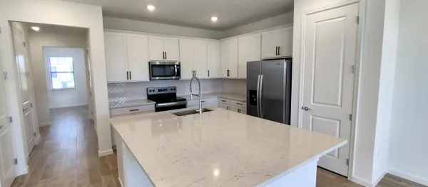 a kitchen with stainless steel appliances a refrigerator and a stove top oven