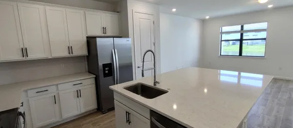 a kitchen with stainless steel appliances a sink a microwave a stove and white cabinets