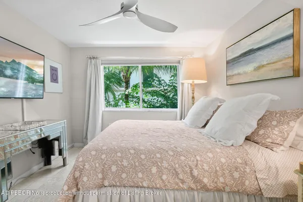 a bedroom with a bed a chandelier and a window