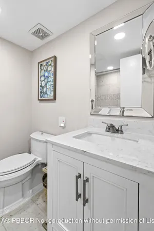 a bathroom with a sink a toilet and mirror