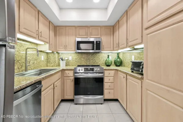 a kitchen with stainless steel appliances granite countertop a stove a sink and a microwave