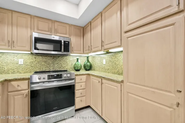 a kitchen with granite countertop white cabinets and stainless steel appliances