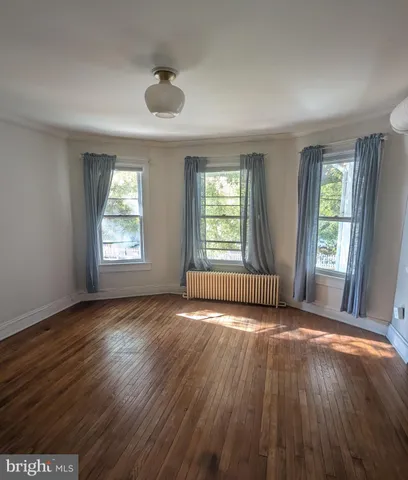 a view of room with window and wooden floor