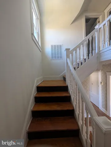 a view of a big room with wooden floor and windows