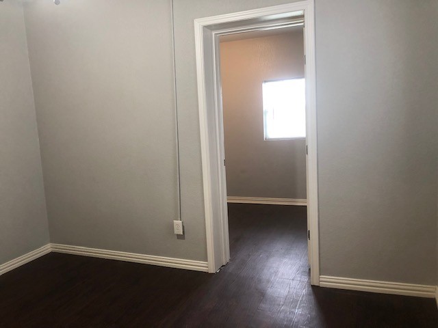 309 Hutcheson Street, Unit 8 Houston, TX 77003 - Photo 9 of 13 a view of an empty room with wooden floor and a window