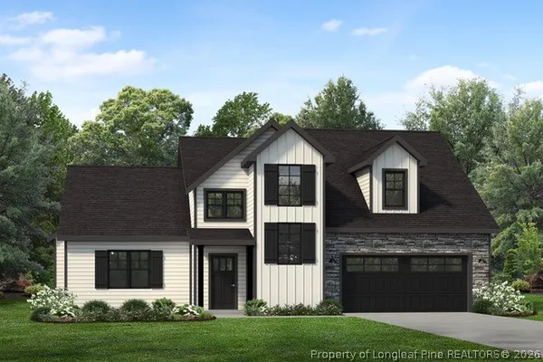 a front view of a house with a garden and yard