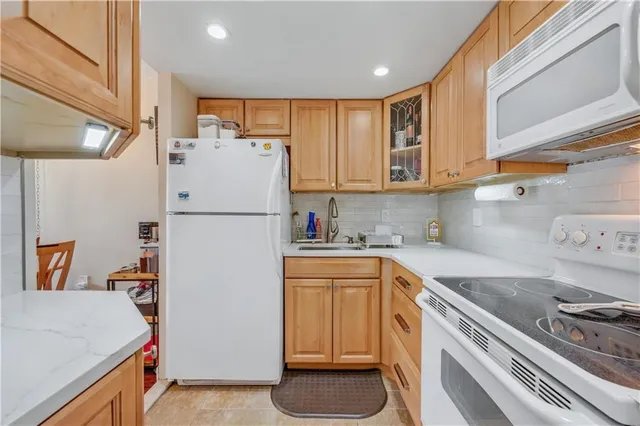 a kitchen with a refrigerator sink stove and cabinets